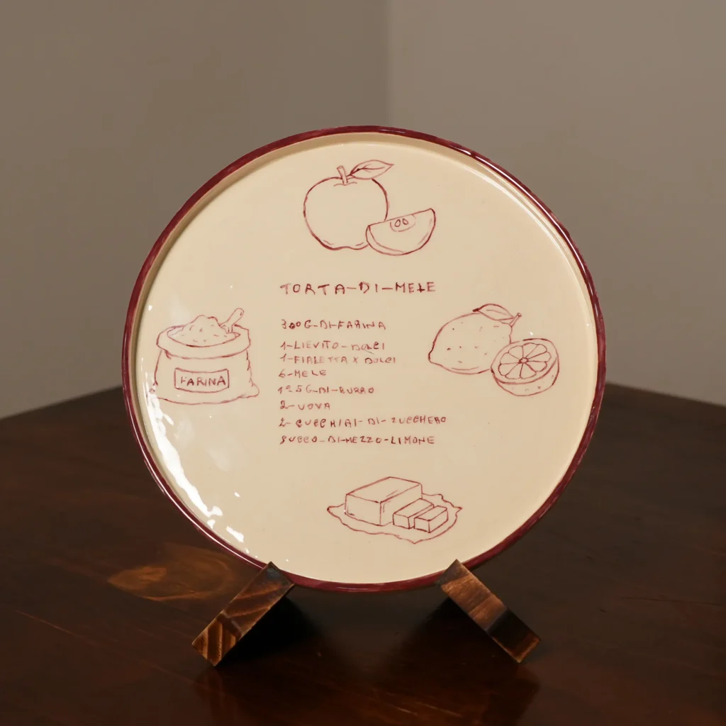 A handwritten torta di mele recipe painted by hand onto a custom ceramic plate, in the original handwriting