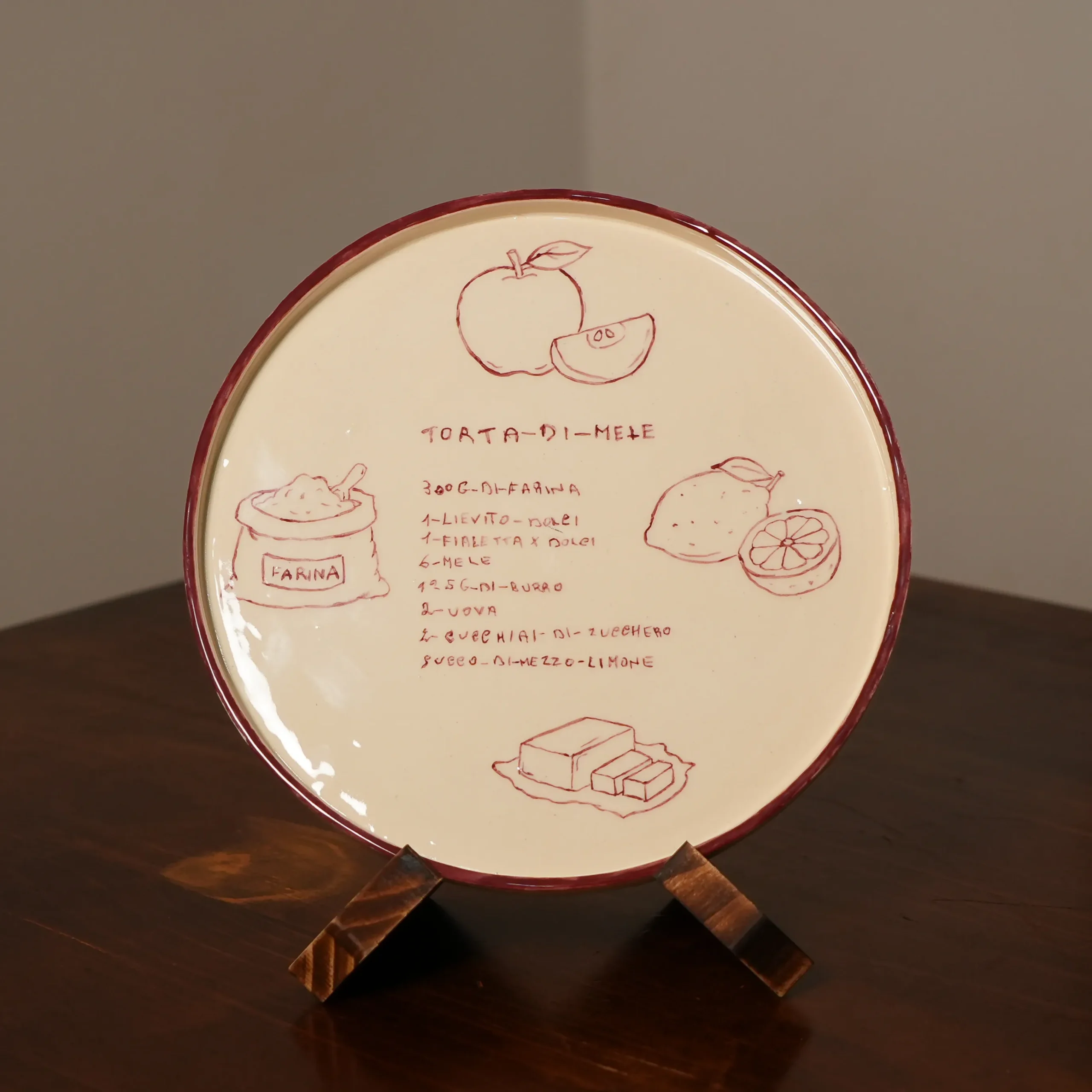 A handwritten torta di mele recipe painted by hand onto a custom ceramic plate, in the original handwriting