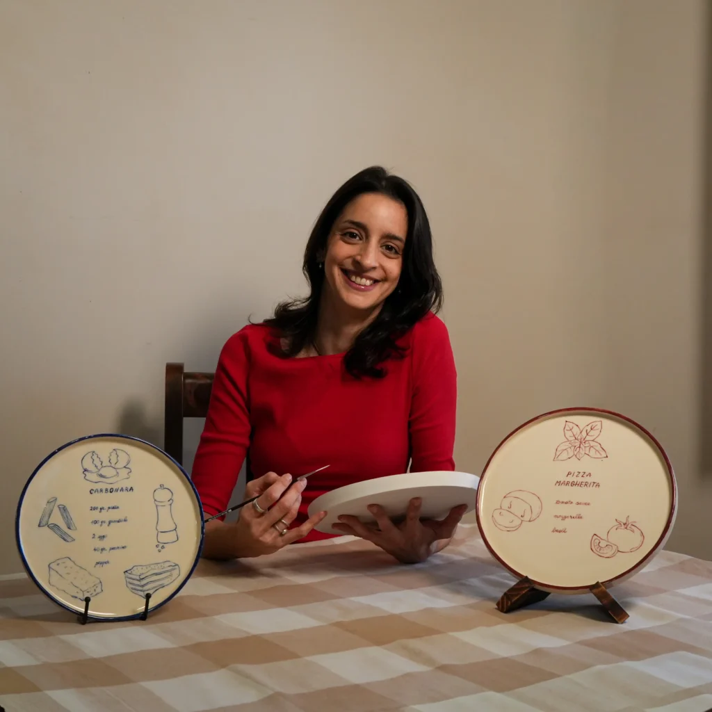Franci, an Italian-trained art conservator, hand-painting a ceramic plate in her Western Australian studio