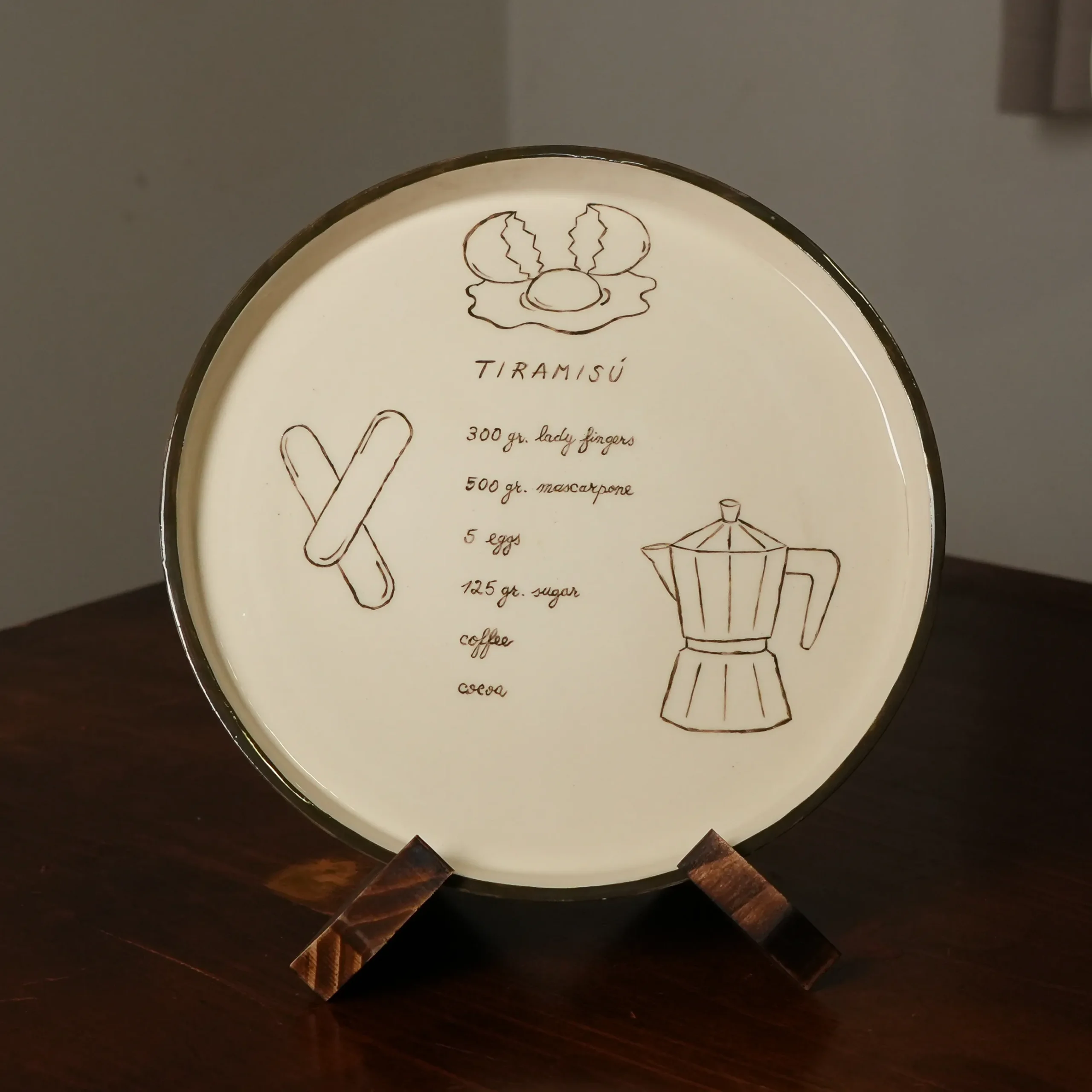 Hand-painted Tiramisù plate displayed on its stand, by Franci Pots