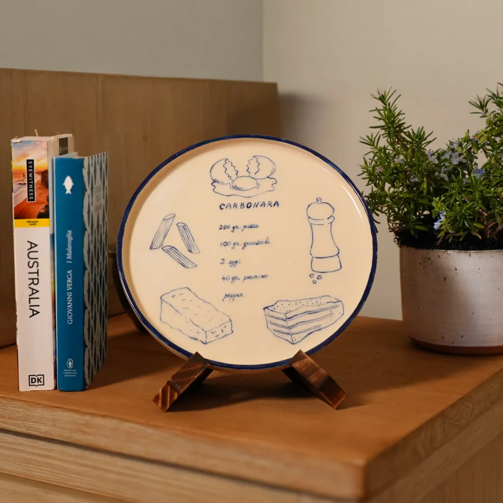 Hand-painted Italian recipe plate by Franci Pots, displayed on a sideboard in a cultured, lived-in home